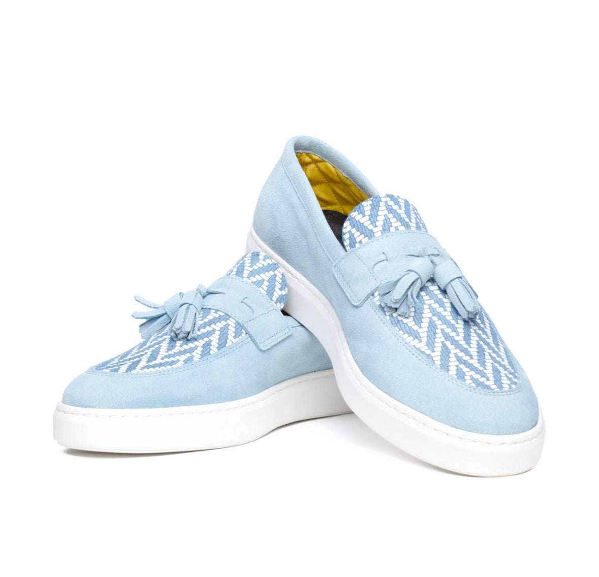 Pair of light blue suede sneakers with white zigzag leather pattern